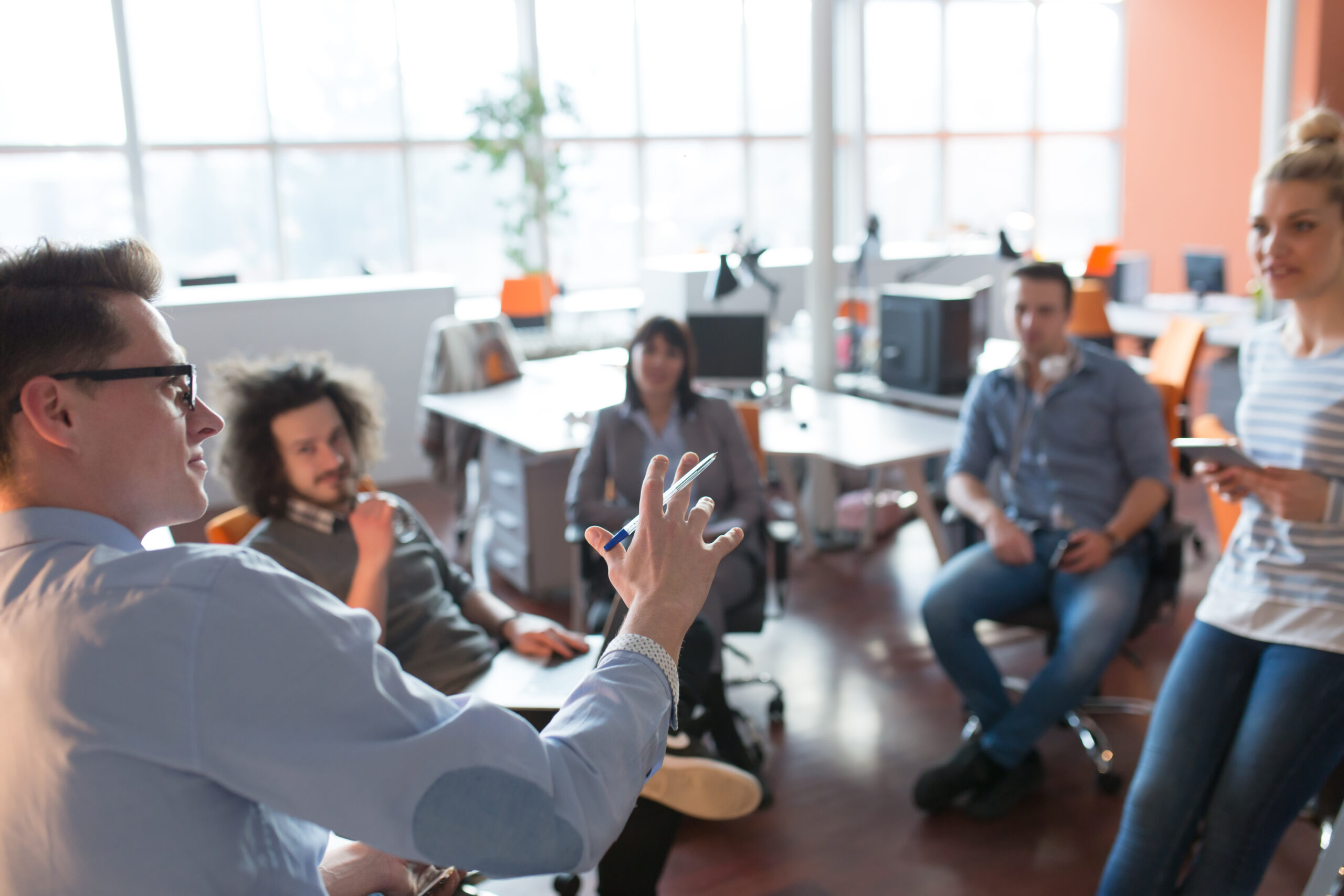 Group of a young business people discussing business plan  in the office