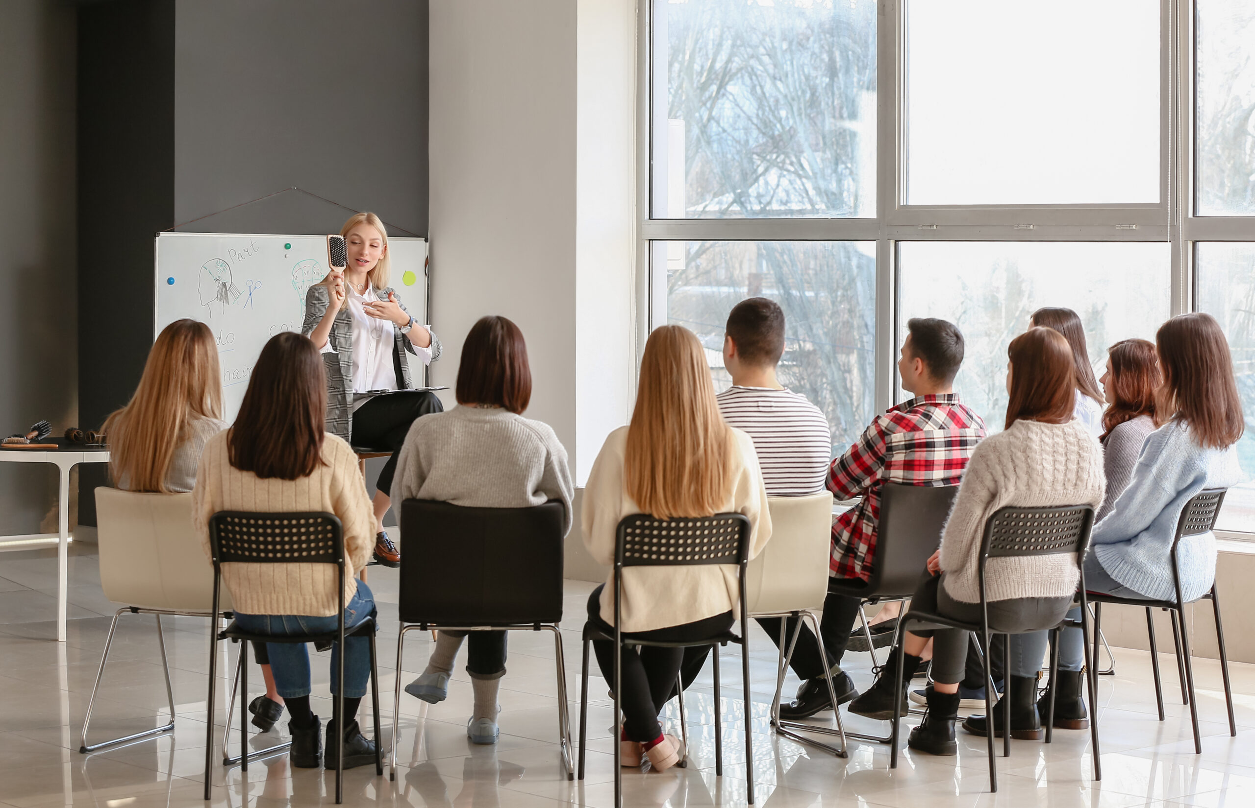 Professional hairdresser teaching young people in office